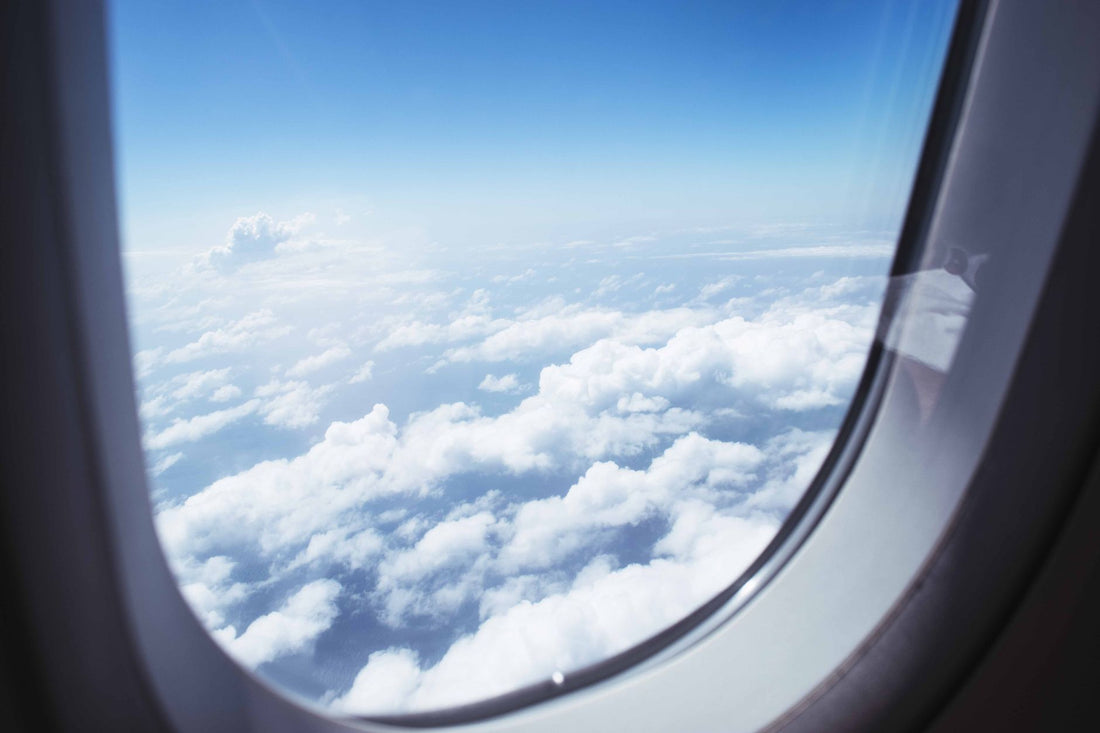 Pasajero mirando el móvil junto a la ventanilla del avión, donde la eSIM no da conexión en pleno vuelo