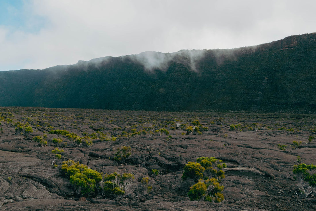 Senderista con el movil y una eSIM para la Isla de la Reunion ante el volcan Piton de la Fournaise