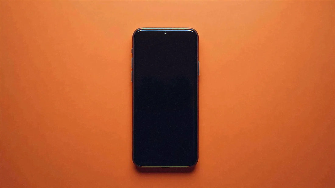暖色の背景の中央に置かれたスマホです。