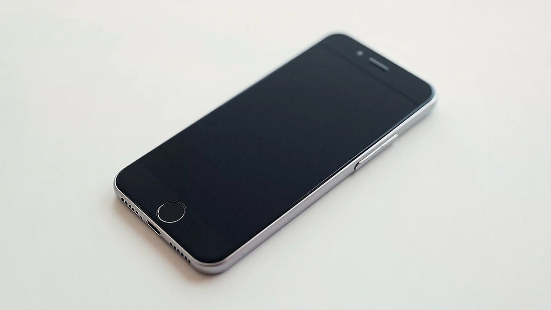 Teléfono móvil moderno con pantalla negra sobre superficie neutra