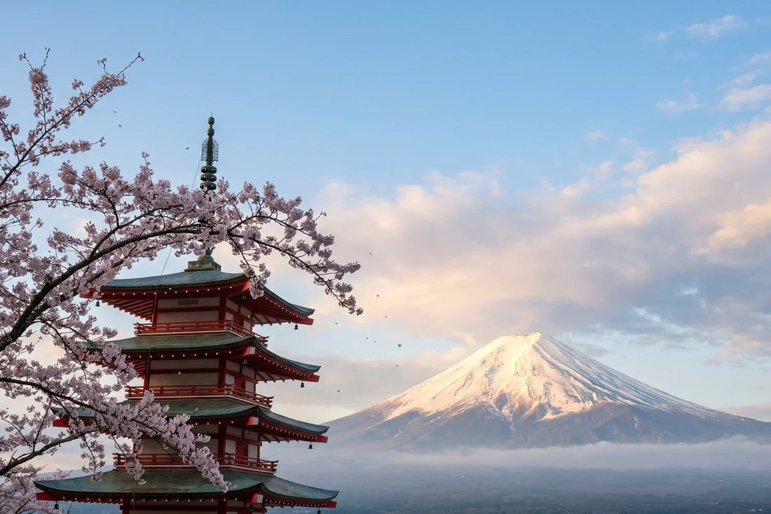 Monte Fuji nevado al atardecer junto a una pagoda japonesa roja entre cerezos en flor, paisaje para eSIM Japón
