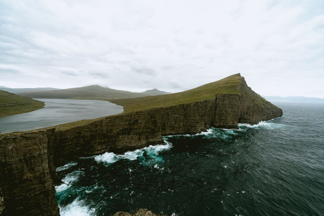 Excursionista con el móvil y una eSIM ante los acantilados de las Islas Feroe