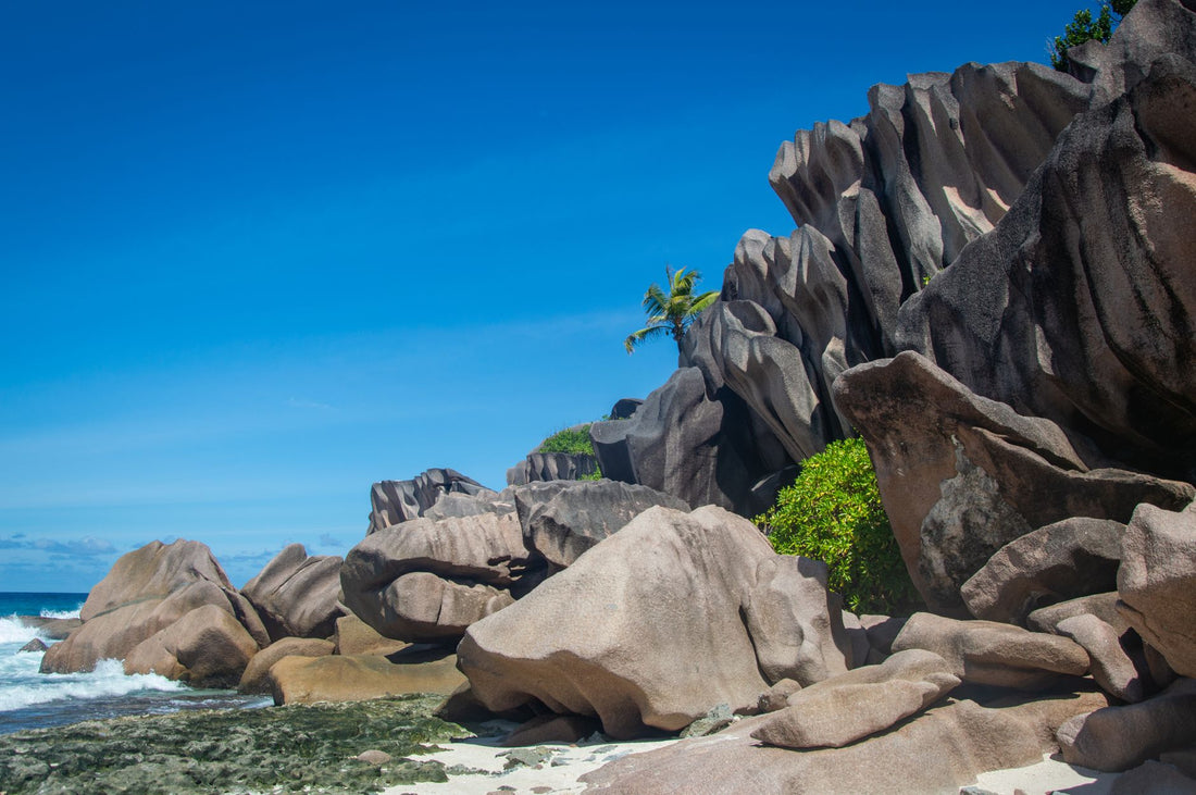 Viajero con el móvil y una eSIM en una playa de granito de Seychelles